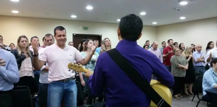 A igreja louvando de pé na sala do hotel, em 2015