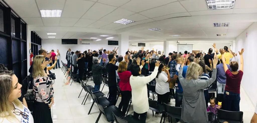 A igreja em adoração, de mãos levantadas, na sala da Rua Nova Trento, em 2016